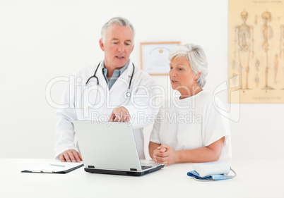 Doctor and his patient looking at the laptop