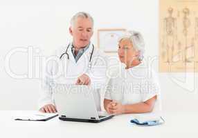 Doctor and his patient looking at the laptop