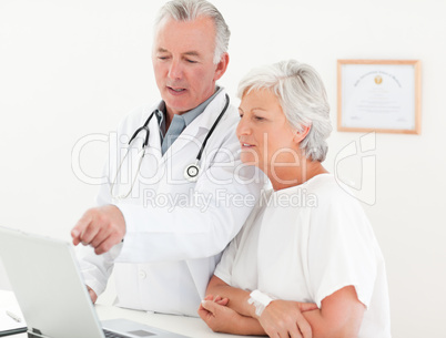 Doctor and his patient looking at the laptop