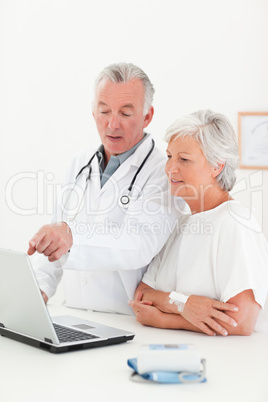 Doctor and his patient looking at the laptop