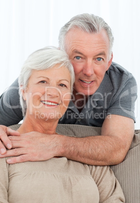 Lovers hugging while they are looking at the camera