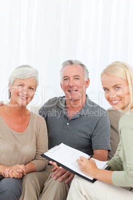 Seniors with doctor looking at the camera at home