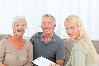 Seniors with doctor looking at the camera at home
