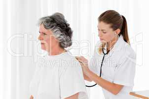 Pretty nurse taking the heartbeat of her patient