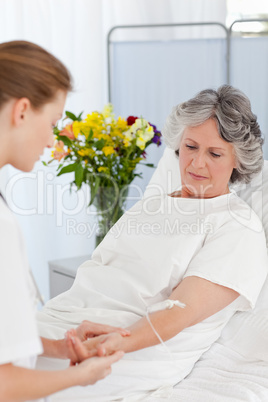Nurse putting a drip on the arm of her patient