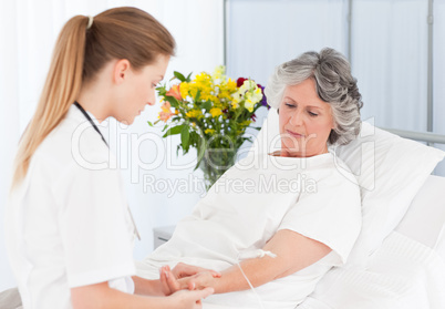 Nurse putting a drip on the arm of her patient