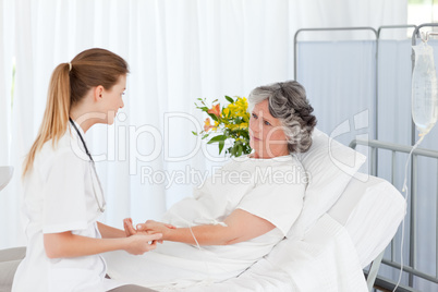 Nurse putting a drip on the arm of her patient