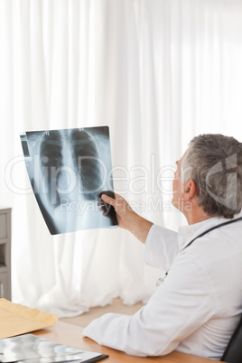 A senior doctor looking at the X-ray