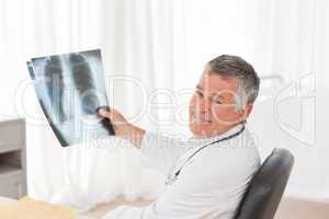 A senior doctor looking at the X-ray