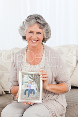 Smiling woman showing a picture of her grandchild