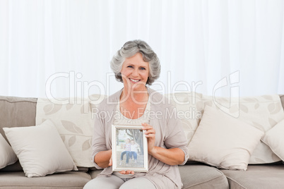 Smiling woman showing a picture of her grandchild