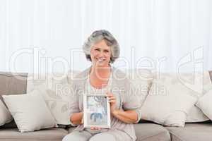 Smiling woman showing a picture of her grandchild