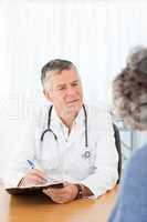 A senior doctor talking with his patient