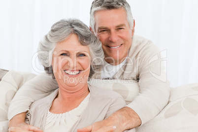 Mature couple looking at the camera at home