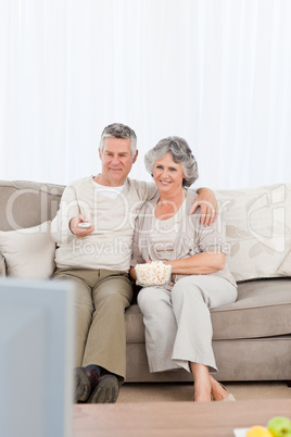 Mature couple watching tv in their living room