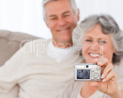 Mature couple taking a photo of themselves at home