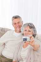 Mature couple taking a photo of themselves at home