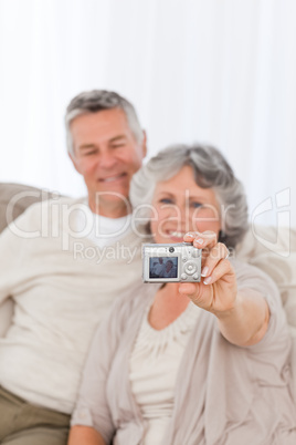 Mature couple taking a photo of themselves at home