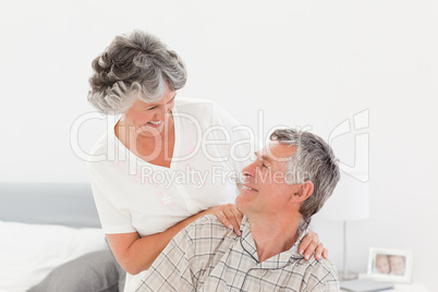 Retired woman giving a massage to her husband at home