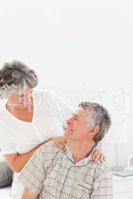 Retired woman giving a massage to her husband at home