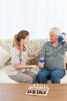 Lovely nurse helping her patient to do exercises