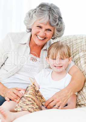 Grandmother helping her little girl to knit