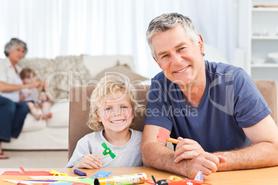 Little boy drawing with his grand father