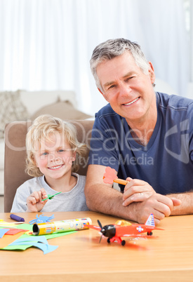 Little boy drawing with his grand father