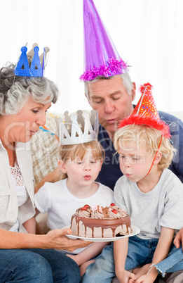 Children blowing on the birthday cake