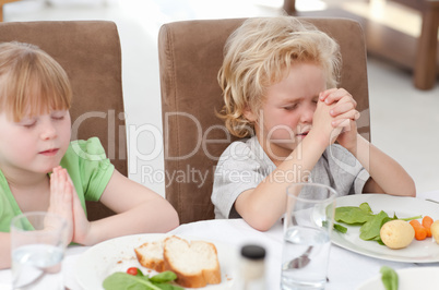 Children praying at the table