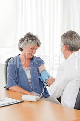 A senior doctor taking the blood pressure of his patient