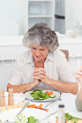 Woman praying at the table