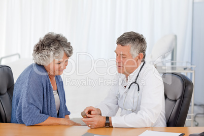 A senior doctor with his patient in his office