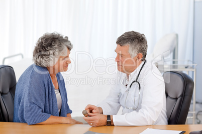 A senior doctor with his patient in his office