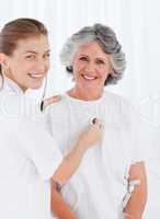 Retired patient with her nurse looking at the camera