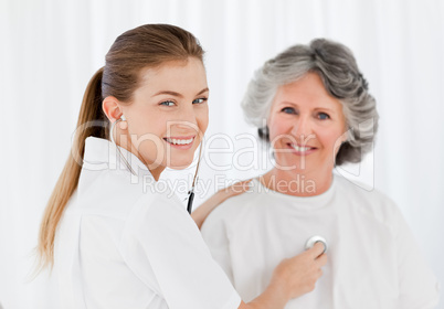 Retired patient with her nurse looking at the camera