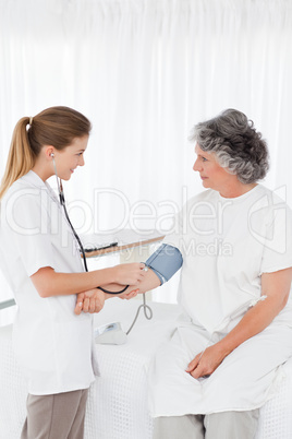 Nurse taking the blood pressure of her patient