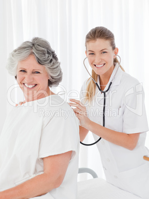 Pretty nurse taking the heartbeat of her patient