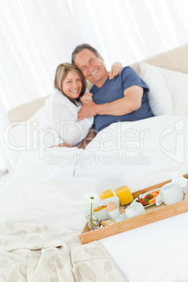 Lovely couple having breakfast in their bed