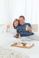 Lovely couple having breakfast in their bed