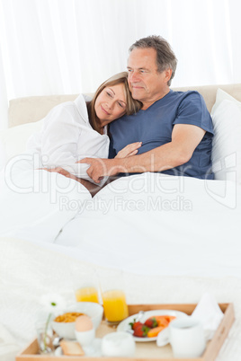 Lovely couple having breakfast in their bed