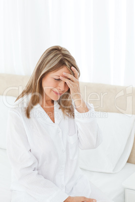 Woman having a headache on her bed
