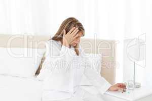 Woman having a headache on her bed