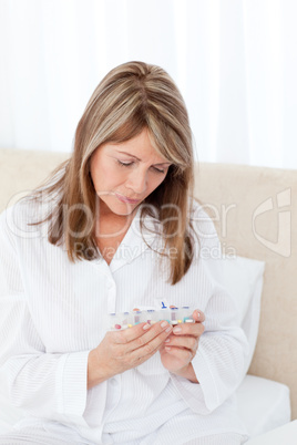 Sick woman taking her pills at home