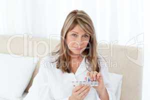 Sick woman taking her pills at home