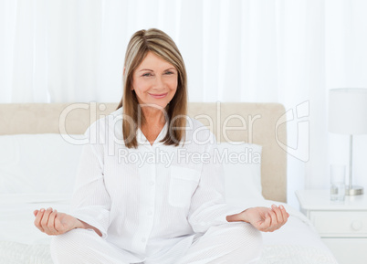 Senior practicing yoga on her bed