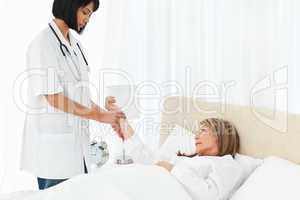 Nurse taking the pulse of her patient