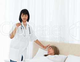 Nurse taking the temperature of  her patient