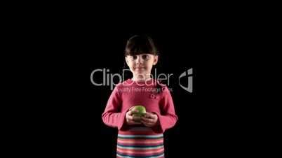 girl eating apple on black background