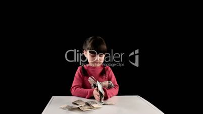 Girl finds money on black background